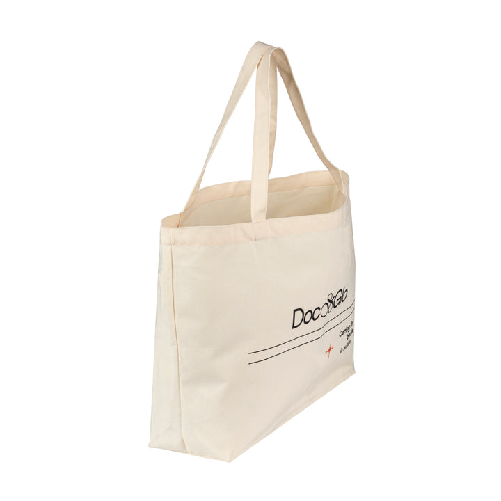 Beige tote bag with Doc & Glo branding on a white background
