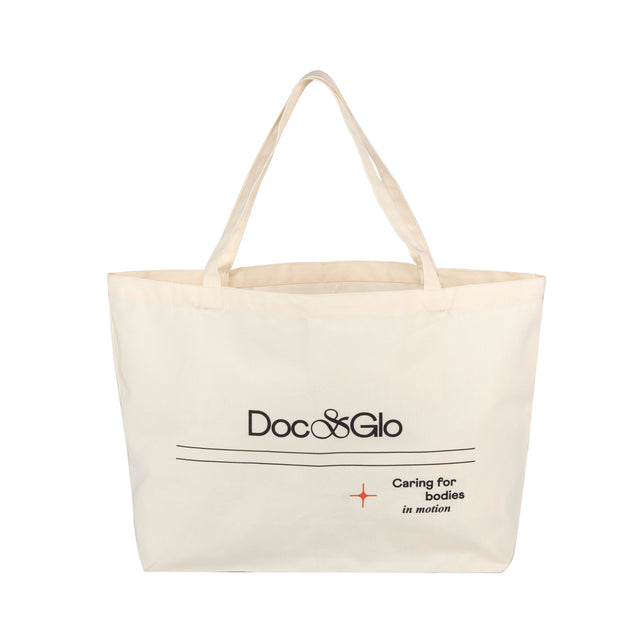 Beige large tote bag with 'Doc & Glo' branding on a white background